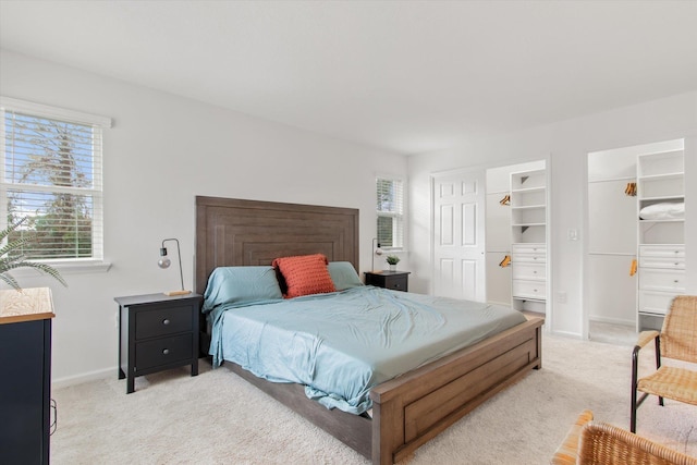 carpeted bedroom with a walk in closet and a closet