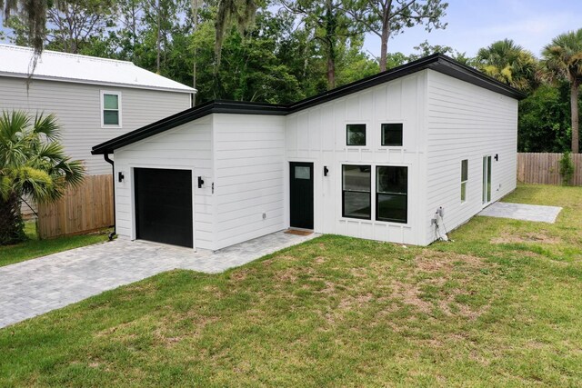 461 S Woodlawn St, Saint Augustine, FL 32084 - back of property featuring an attached garage, board and batten siding, and decorative driveway