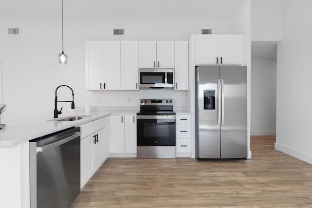 461 S Woodlawn St, Saint Augustine, FL 32084 - kitchen with stainless steel appliances, light wood-style floors, light countertops, and white cabinetry
