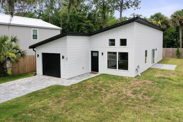 461 S Woodlawn St, Saint Augustine, FL 32084 - back of property featuring an attached garage, board and batten siding, and decorative driveway