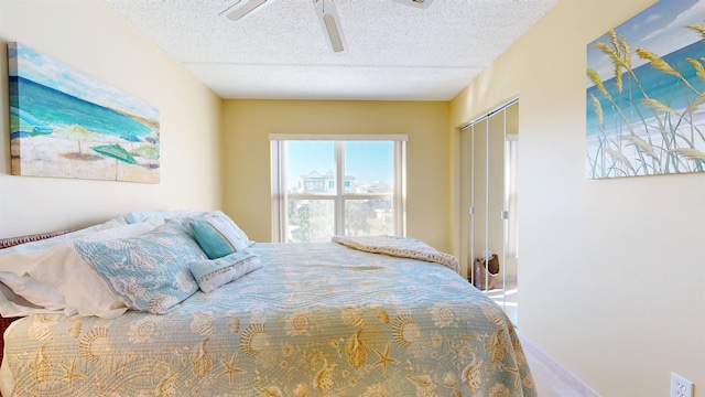 bedroom with a closet, ceiling fan, and a textured ceiling