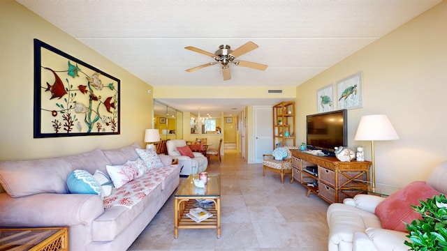 living area with baseboards, visible vents, and ceiling fan with notable chandelier