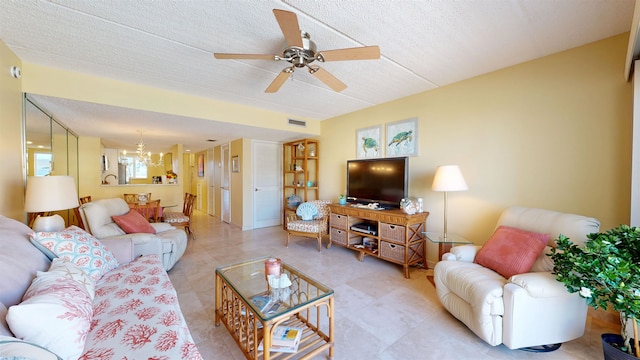 living area with a textured ceiling, ceiling fan with notable chandelier, and visible vents