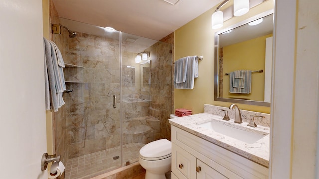 full bathroom with a stall shower, vanity, and toilet