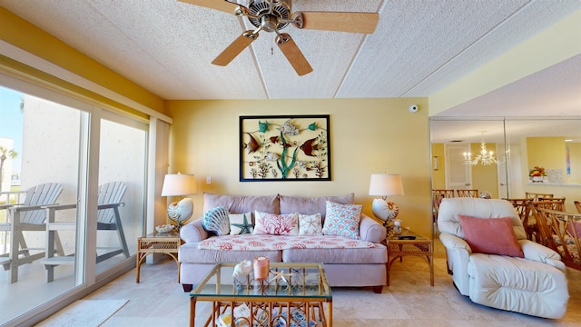 living room with ceiling fan with notable chandelier and a textured ceiling