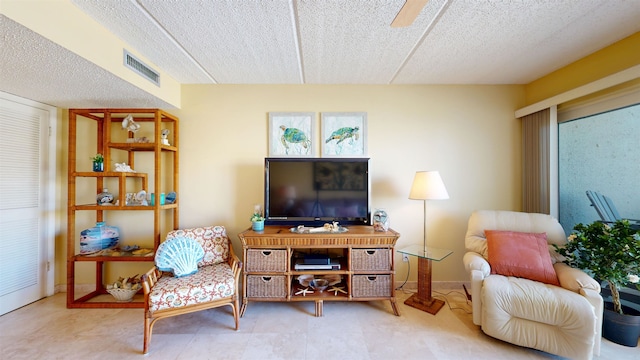 living area with visible vents, a textured ceiling, and baseboards