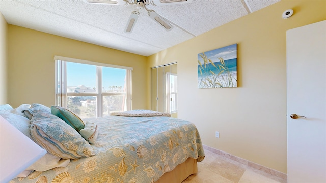 bedroom featuring a textured ceiling, a ceiling fan, and baseboards