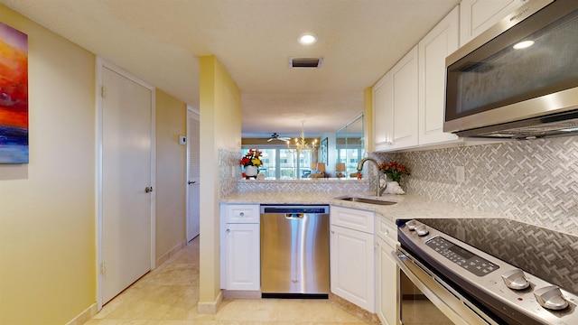 kitchen featuring stainless steel appliances, a sink, visible vents, and white cabinets