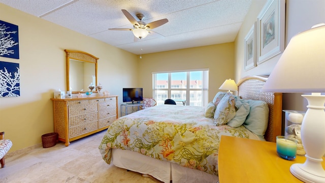 bedroom with ceiling fan and a textured ceiling