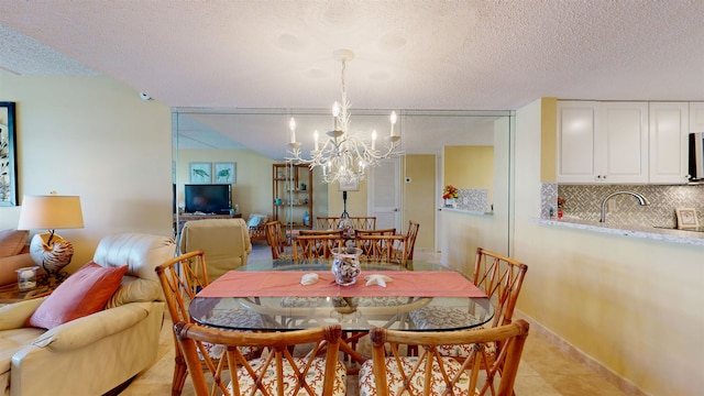 dining area with a chandelier, a textured ceiling, and baseboards