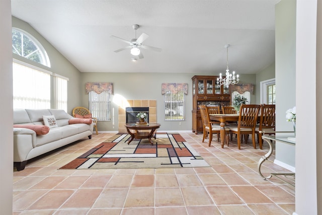 tiled living room with lofted ceiling and ceiling fan with notable chandelier