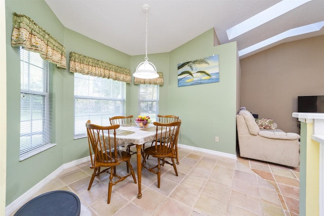 tiled dining space featuring lofted ceiling