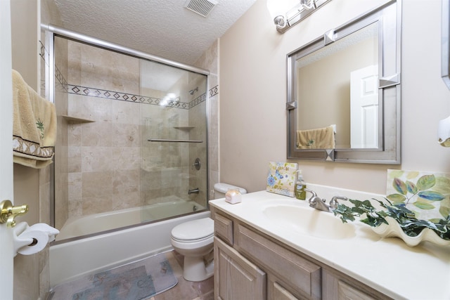 full bathroom with a textured ceiling, toilet, vanity, and shower / bath combination with glass door