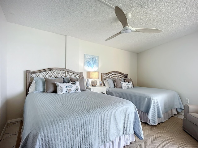 bedroom with light tile patterned floors, a textured ceiling, and ceiling fan