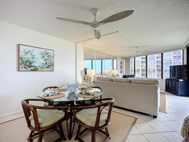 tiled dining space featuring ceiling fan and a textured ceiling