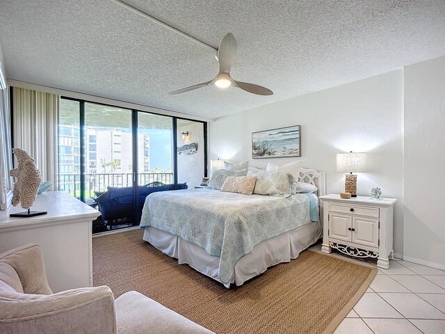 bedroom featuring ceiling fan, access to exterior, and a textured ceiling