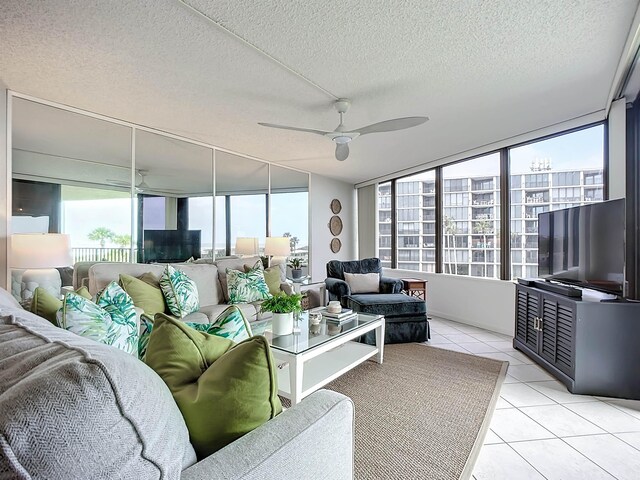 tiled living room featuring floor to ceiling windows, ceiling fan, and a textured ceiling