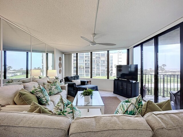 tiled living room with a textured ceiling, a wall of windows, and ceiling fan