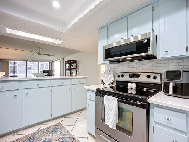 kitchen featuring ceiling fan, light tile patterned floors, appliances with stainless steel finishes, and tasteful backsplash