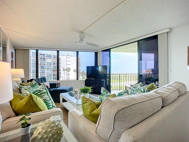 living room featuring a wall of windows, a healthy amount of sunlight, and ceiling fan