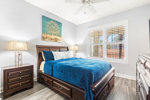 bedroom featuring ceiling fan, light wood-style flooring, and baseboards