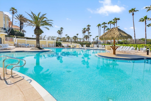 pool with a patio area and fence