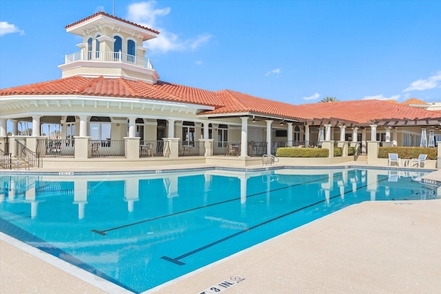 pool with a patio area and fence