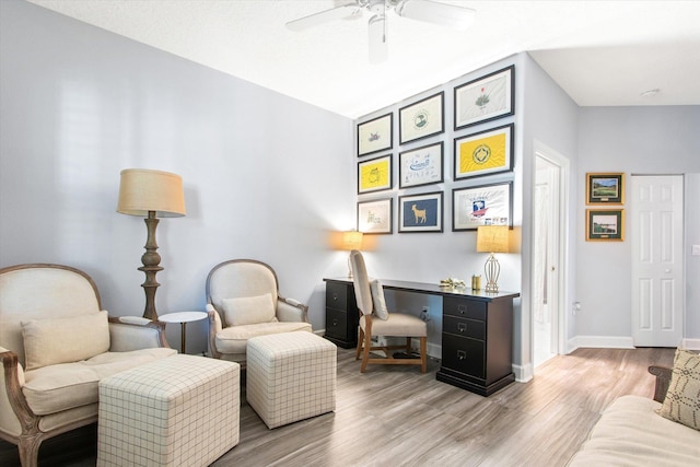 sitting room featuring ceiling fan, baseboards, and wood finished floors