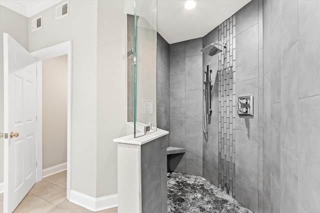 bathroom with tile patterned floors, walk in shower, visible vents, and baseboards