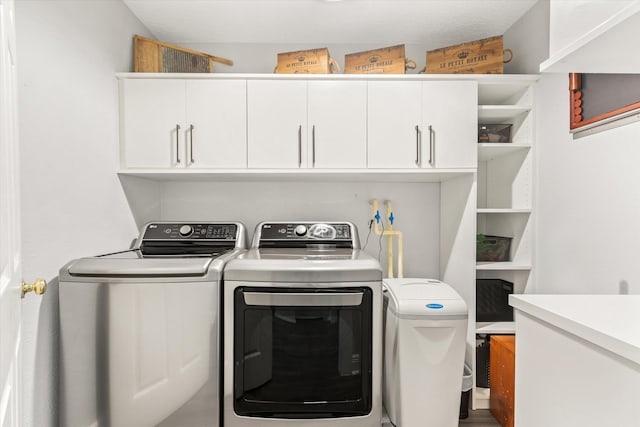 laundry room with cabinet space and washer and clothes dryer