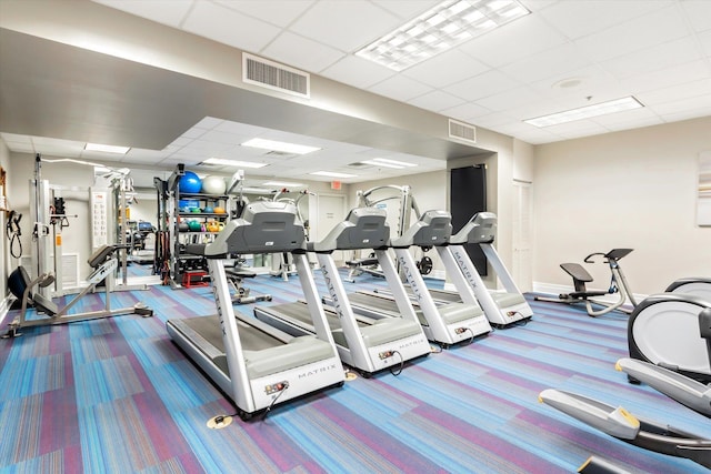 workout area with a paneled ceiling, visible vents, and carpet flooring