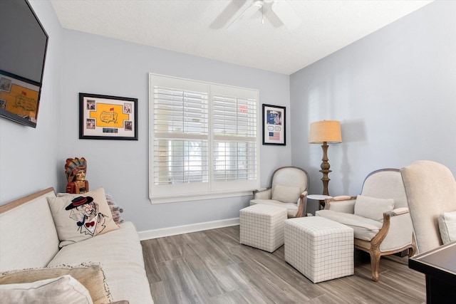 sitting room with ceiling fan, baseboards, and light wood-style floors