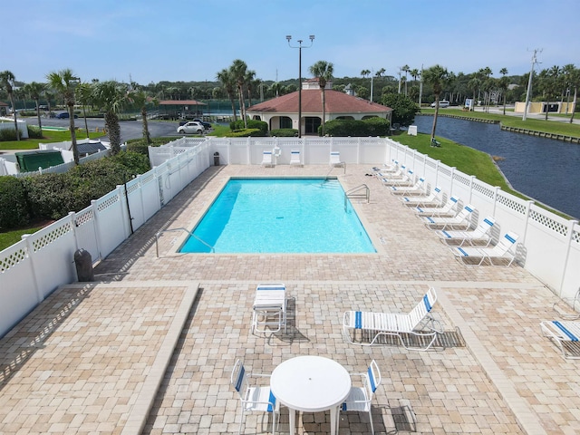 view of pool with a water view and a patio