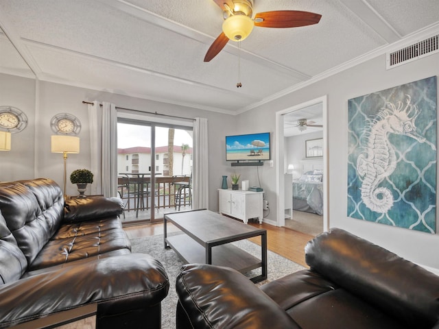 living room featuring hardwood / wood-style floors, a textured ceiling, and ornamental molding