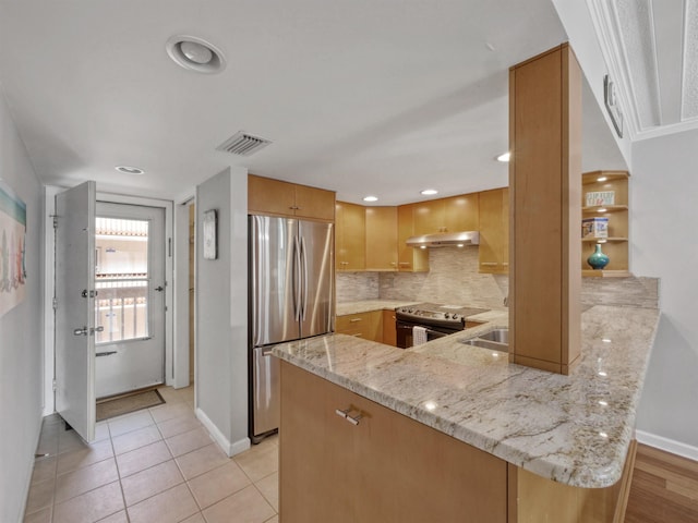 kitchen with kitchen peninsula, appliances with stainless steel finishes, decorative backsplash, light stone counters, and light tile patterned floors