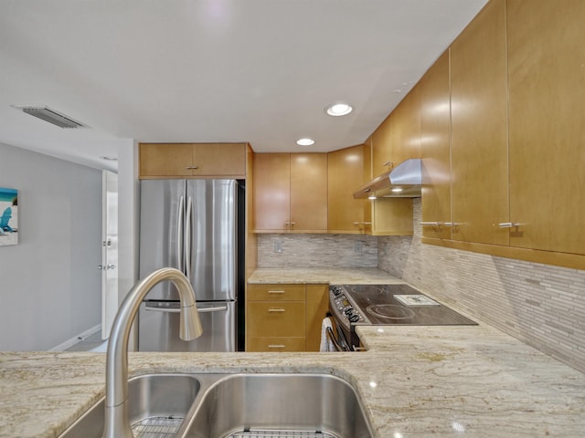 kitchen featuring backsplash, light stone counters, range hood, and appliances with stainless steel finishes