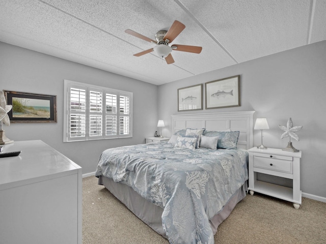 bedroom featuring a textured ceiling, ceiling fan, and light carpet