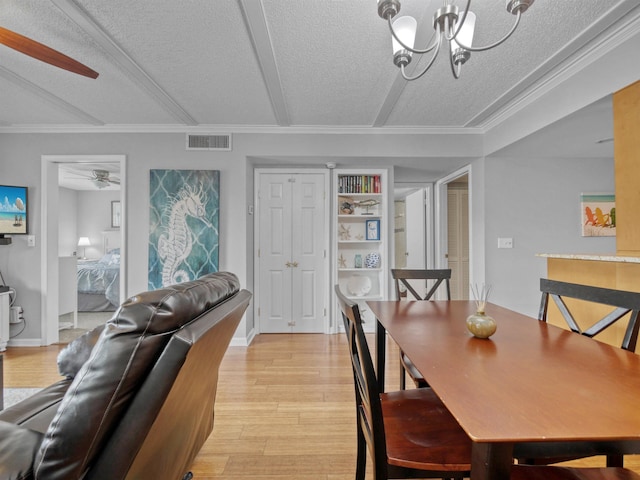 dining space featuring light wood-type flooring, a textured ceiling, ceiling fan with notable chandelier, and ornamental molding