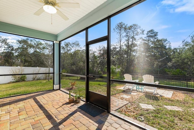 unfurnished sunroom featuring ceiling fan