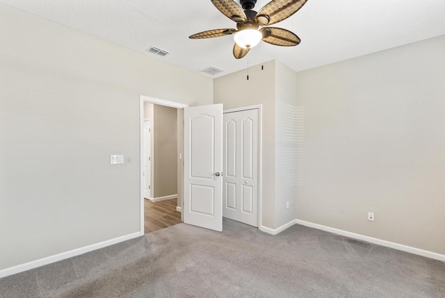 unfurnished bedroom featuring carpet floors, a closet, visible vents, and baseboards