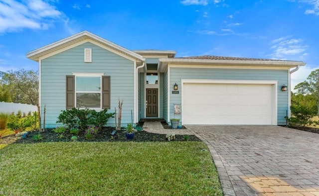 ranch-style house with a garage, decorative driveway, and a front lawn