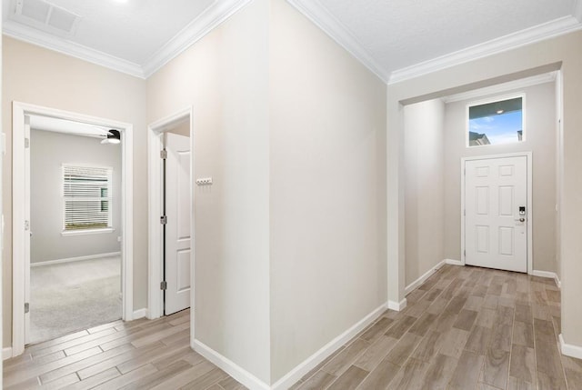 foyer entrance with baseboards, ornamental molding, visible vents, and wood tiled floor