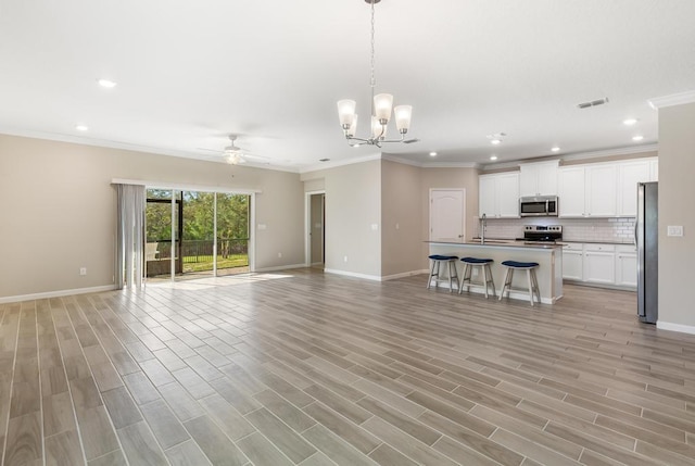 unfurnished living room featuring light wood-style floors, visible vents, baseboards, and ceiling fan with notable chandelier