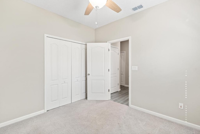 unfurnished bedroom with a closet, visible vents, carpet flooring, ceiling fan, and baseboards