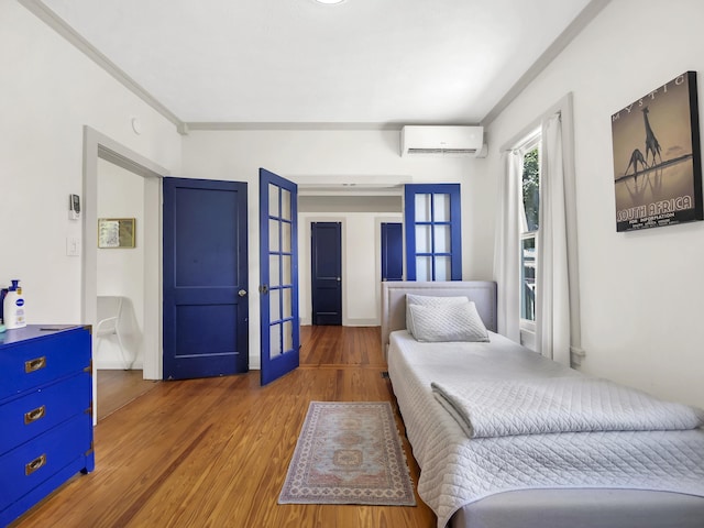 8 Davis St, Saint Augustine, FL 32084 - bedroom with french doors, a wall unit AC, wood finished floors, and crown molding