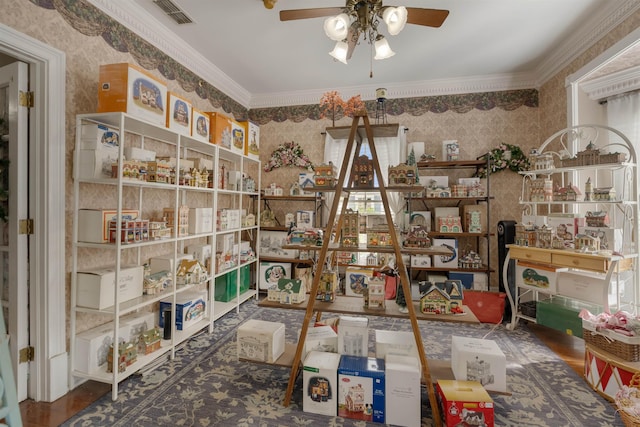 interior space with ceiling fan, wood-type flooring, and ornamental molding