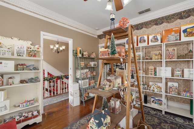 interior space featuring dark hardwood / wood-style floors, crown molding, and ceiling fan with notable chandelier