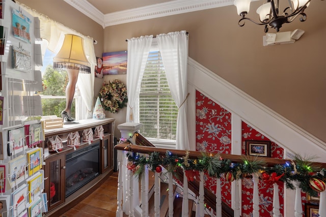 interior space with a notable chandelier, wood-type flooring, and crown molding