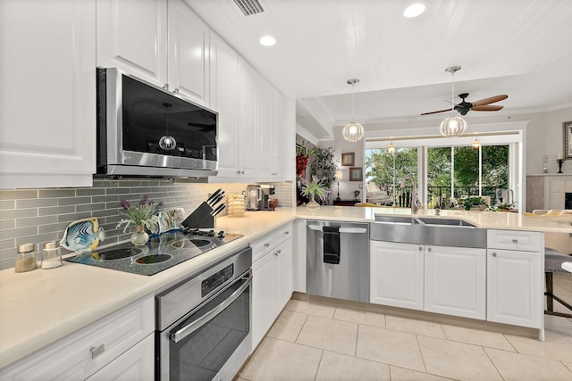 kitchen featuring white cabinets, kitchen peninsula, and stainless steel appliances