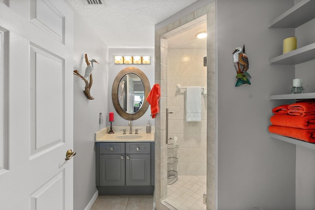 bathroom featuring tile patterned floors, vanity, an enclosed shower, and a textured ceiling